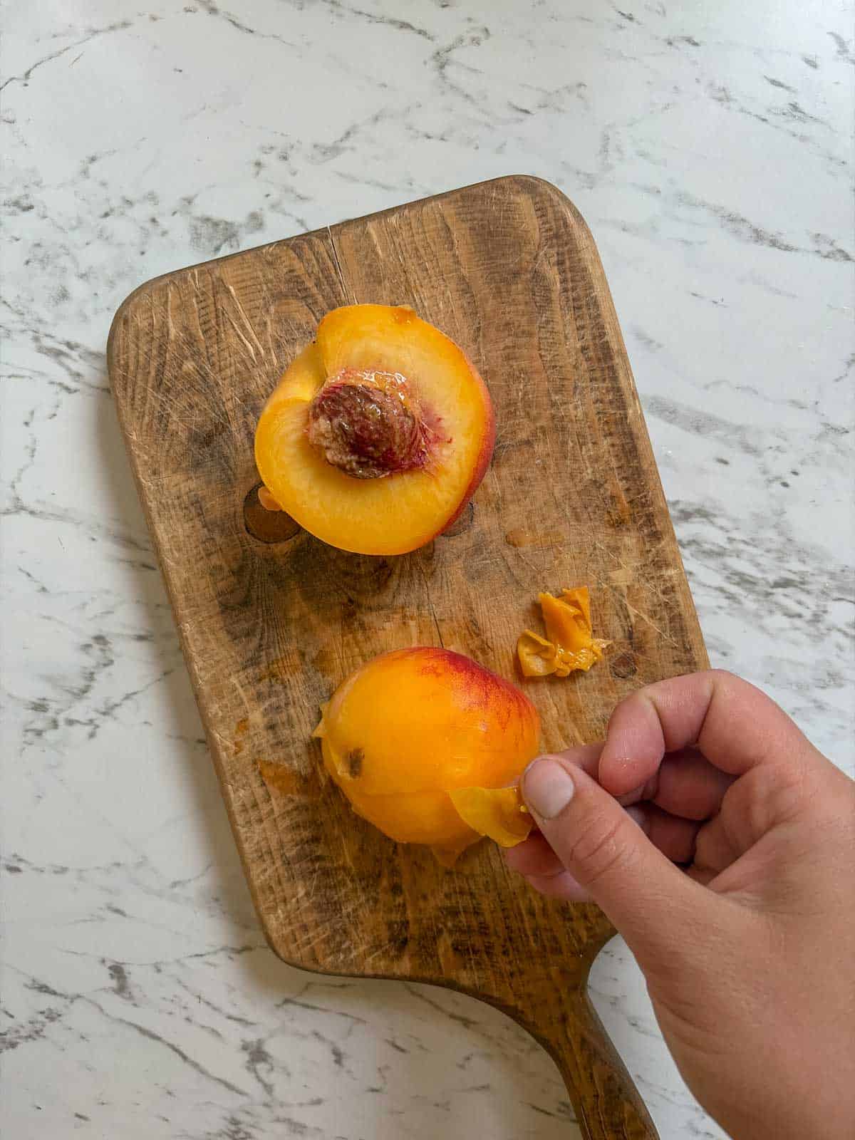 Removing skin from a peach.